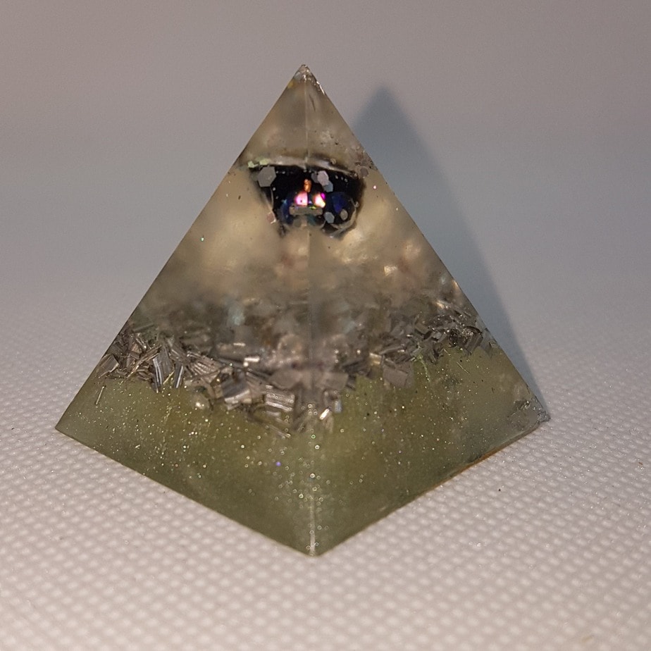 Processing Abundance Orgone Orgonite Pyramid 4cm - A heart of A huge Herkimer Diamond, with Obsidian for protection. Silver and Aluminium for Piezoelectric effect. Obsidians powerful gravitational pull gives it the ability to draw our your deepest and darkest insecurities and demons.